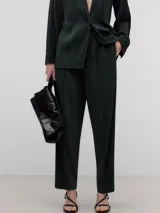 Pantalón verde botella con textura arrugada, corte recto, cintura elástica en la parte trasera y trabillas para cinturón.