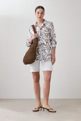 Camisa de lino color blanco con estampa abstracta color chocolate, de manga larga y cuello clásico.