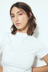 Top blanco de manga corta con cuello alto, corte ajustado al cuerpo.