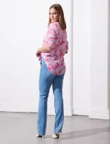 Blusa celeste con estampado blanco, de gasa, con cuello a la base y escote en V. Tiene abertura con botones, bolsillos delanteros y mangas 3/4 regulables con presilla y botón. El ruedo termina con un nudo.