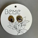 Aros tipo caravana artesanales de bronce con circonias violetas y perno de plata 925.