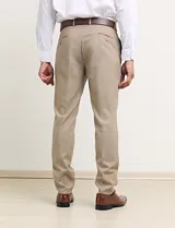 Ambo de dos piezas color tostado, compuesto por un saco entallado de dos botones y pantalón de vestir de corte recto.