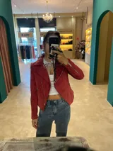 Chaqueta estilo biker de gamuza genuina color bordó, con cuello solapa, cierre asimétrico y cierres metálicos en los bolsillos y puños.