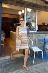 Vestido corto sin mangas, de tejido de punto en color azul marino con efecto jaspeado o tweed en tonos claros. Presenta un corte amplio y relajado, con cuello redondo y bordes en contraste.