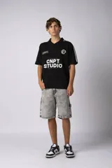 Remera de corte oversize color negro, con cuello redondo y detalle de costura en forma de X en el frente.