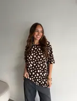 Remerón de viscosa color bordó con estampado de lunares pequeños blancos, cuello redondo y mangas cortas de corte holgado.