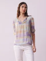 Blusa de gasa estampada con cuello a la base, escote en V plisado y lazo de ajuste. Delantera con detalles en puntilla y manga corta con puño fruncido.