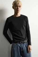Camiseta de manga larga con cuello redondo, confeccionada en tejido con estructura de canalé y corte relajado.