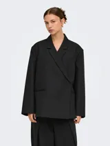 Blazer oversize color negro, con solapa clásica, bolsillos con ribete y diseño amplio de manga larga.