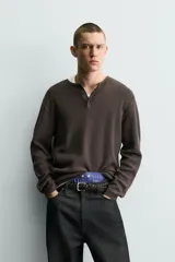 Jersey relaxed fit de punto acanalado color marrón oscuro, con cuello redondo tipo panadera y cierre frontal de tres botones. Tiene manga larga y efecto lavado.