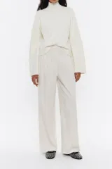 Pantalón de pana color beige claro, de corte ancho y tiro alto, con pliegues delanteros y cintura elástica.