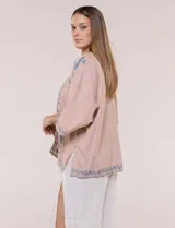 Cardigan tipo kimono verde claro con detalles bordados en marrón en los bordes y las mangas, de corte amplio y mangas tres cuartos.