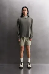 Camiseta de entrenamiento regular fit color gris oscuro, confeccionada en tejido técnico ligero y elástico con estructura. Cuenta con cuello redondo, manga larga y logo estampado en el bajo.