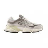 Championes urbanos New Balance modelo 9060, con diseño robusto y futurista en tonos grises, blancos y crema. Presentan una combinación de malla y gamuza, con el logo N característico en los laterales y una suela voluminosa con tecnología de amortiguación.