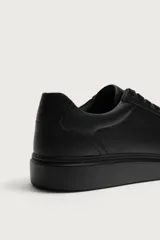 Zapatilla urbana monocolor blanca con cordones al tono, diseño de parte superior lisa, puntera redondeada y suela con volumen.