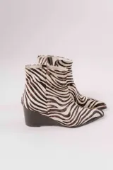 Botas cortas con estampado animal print de cebra, con taco de cuña y punta fina.