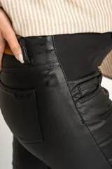 Pantalón negro de corte flare, tiro medio y efecto encerado.