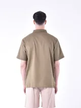 Camisa verde militar de manga corta con cuello clásico y cierre frontal con botones.