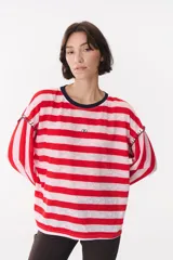 Remera de manga larga con corte oversized, color azul marino con cuello redondo en contraste color marrón. Presenta costuras decorativas a contratono hechas a mano en la zona de los hombros y logo bordado en el centro del pecho.