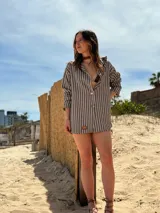 Camisola blanca con rayas verticales finas color marrón, de corte amplio y mangas largas.