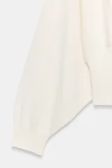 Jersey de cuello redondo color blanco, con manga larga tipo murciélago y acabados en rib elástico.