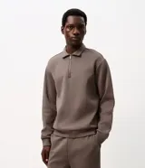 Buzo masculino Marfinno confeccionado en tejido de punto pesado color marrón, con cuello camisero, medio cierre frontal, mangas largas y puños y bajo ajustados.