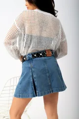 Minifalda de gabardina color marfil, con diseño de tablas y costuras pespunteadas en contraste.