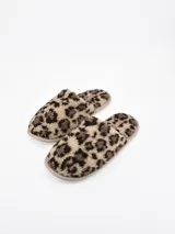 Pantuflas cerradas con estampado animal print tipo leopardo en tonos marrones y negros, con suela acolchada.