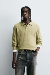 Polo de punto con diseño desagujado, color verde, de corte relajado, manga larga y cuello solapa con cierre frontal de tres botones. Presenta puños y ruedo con acabado en rib.