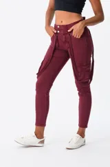 Pantalón cargo bordó de corte skinny, con bolsillos laterales y tiradores ajustables.
