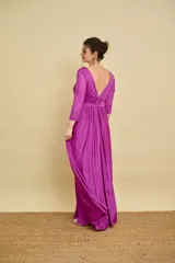 Vestido largo bordó de fiesta, con escote en V pronunciado, nudo drapeado en la cintura y tajo frontal. Las mangas son tres cuartos en tul translúcido con detalles sutiles.