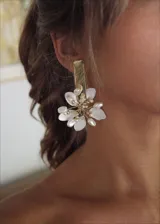 Aros colgantes dorados con forma de flor, con pétalos de nácar y detalles de perlas.