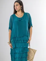 Vestido midi de seda italiana color negro, diseño dos en uno con capa superior de calce amplio, falda con volados y forro interior de algodón elastizado.