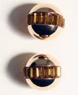 Aros esféricos dorados con una franja central de cristales facetados marrones.