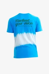 Remera azul con efecto batik blanco en el centro y estampado verde en la espalda con la frase "Manifest your vision The Uniform Club".