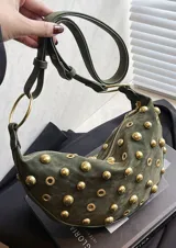 Bolso pequeño de hombro con forma de media luna, color negro, decorado con tachas redondas doradas. Cuenta con una correa ajustable y herrajes dorados.