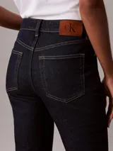 Jeans skinny bootcut de Calvin Klein con lavado clásico oscuro, tiro medio, cierre de botón y cremallera, y diseño clásico de cinco bolsillos.