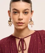 Maxi aros de metal con forma de flor, esmaltados en color borgoña con efecto martillado y detalles dorados. Cierre a rosca.