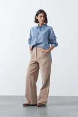 Pantalón de pana color marrón chocolate, de corte recto con bolsillos laterales y cierre frontal.