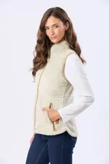 Chaleco de tejido sherpa color beige, con cuello alto y detalles en eco cuero. Diseño sin mangas que proporciona abrigo al torso manteniendo la libertad de movimiento.