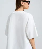 Remera oversize blanca de manga corta, con cuello redondo y diseño holgado, confeccionada en mezcla de algodón y poliéster.