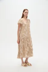 Vestido midi de viscosa con estampado floral en tonos celeste y blanco, cuello en V, mangas cortas y diseño holgado con volados escalonados en la falda.