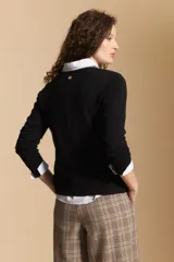 Cardigan negro de tejido suave y liviano, con cierre frontal abotonado y cuello redondo.