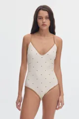 Malla enteriza de color off-white con estampado de lunares negros y vivos en contratono tostado. Presenta escote en V y tirantes finos.