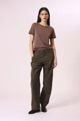 Pantalón de vestir color verde militar, de corte ancho y tiro alto, con pinzas frontales y bolsillos laterales.