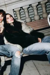 Top asimétrico color gris claro, con escote de un solo hombro. Presenta un tirante ancho decorado con lentejuelas plateadas que cae sobre el pecho y se anuda al cuello tipo halter.