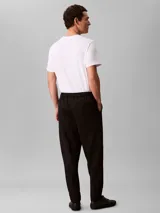 Pantalón de corte ceñido y largo al tobillo, confeccionado en tejido de tricot con cintura elástica. Presenta un diseño minimalista con logo de la marca bordado en el muslo.
