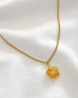 Collar dorado con dije de flor color naranja.