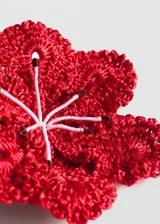 Broche en forma de flor grande realizado en tejido de crochet color rojo, con cierre de gancho en la parte posterior.