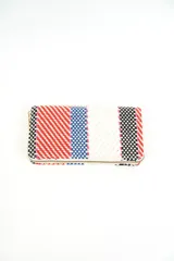 Billetera rectangular de diseño tejido con rayas multicolor en tonos rojo, azul, blanco y negro, con cierre perimetral dorado.
